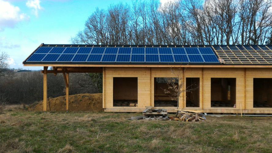 Pose du photovoltaïque terminé, sur maison en bois en construction
