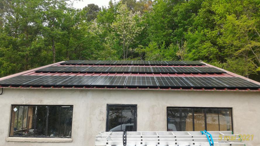 Surimposition photovoltaïque sur un garage de 9KWc composé 24 panneaux SolarEdge de 375Wc, avec espace de circulation entre les panneaux pour faciliter la maintenance et le nettoyage
